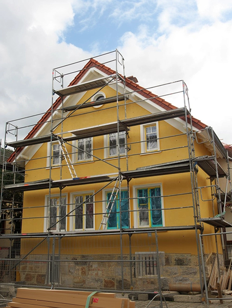 Échafaudage monté devant une maison en rénovation – Travaux de peinture de façade en cours